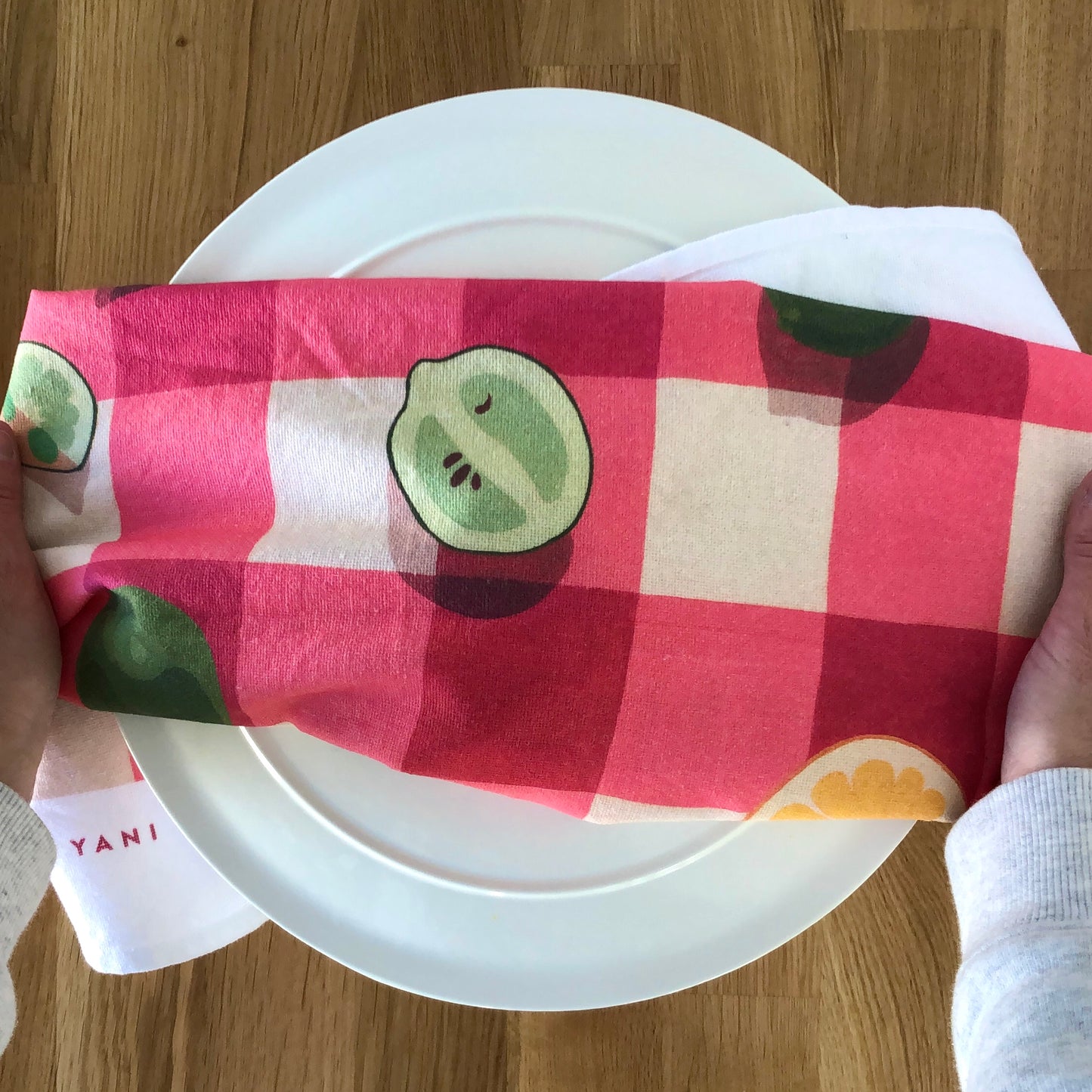 art tea towel of gingham checkered background in pink with lemons and limes