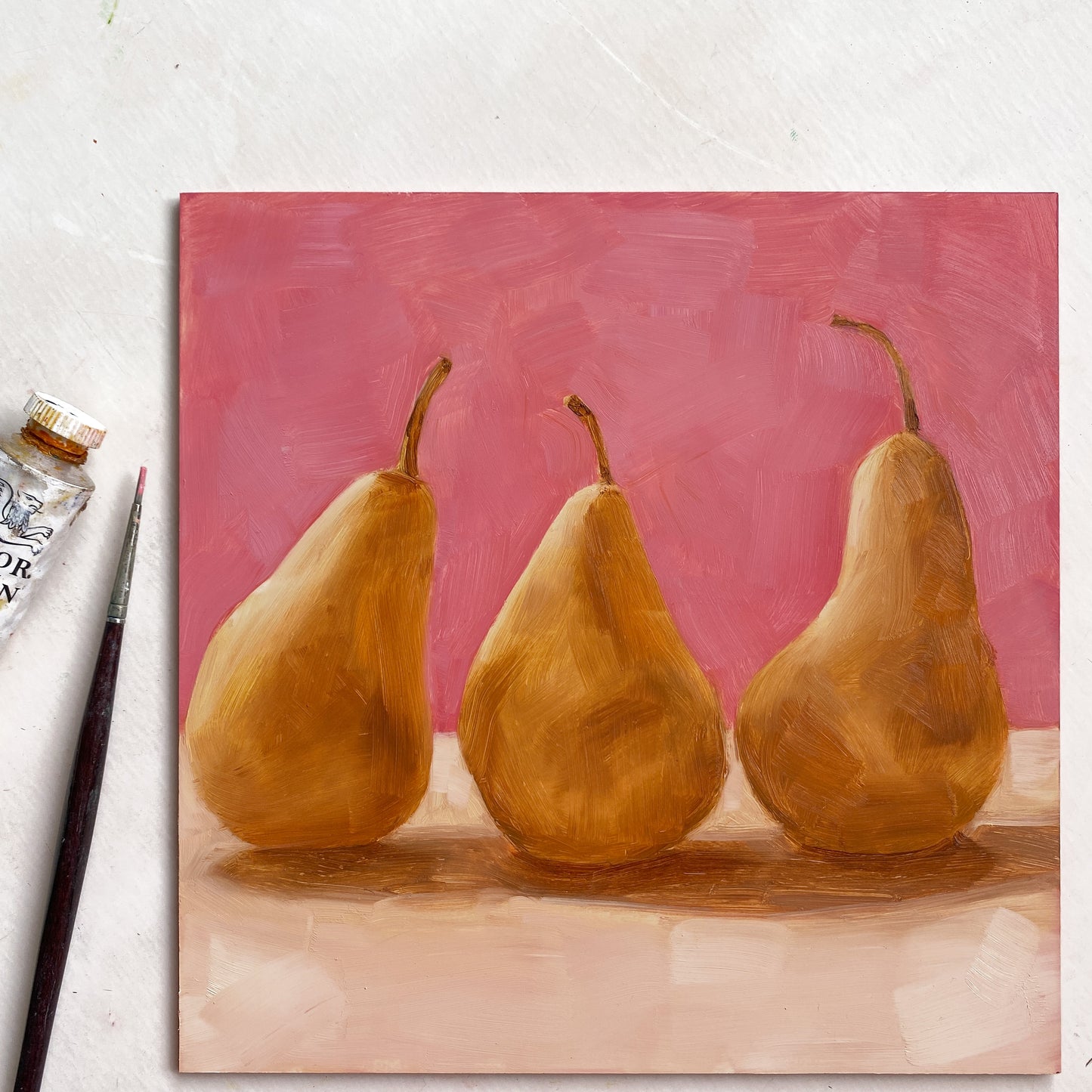 original oil paintings of three beurre Bosc pears on a warm pink and creamy background