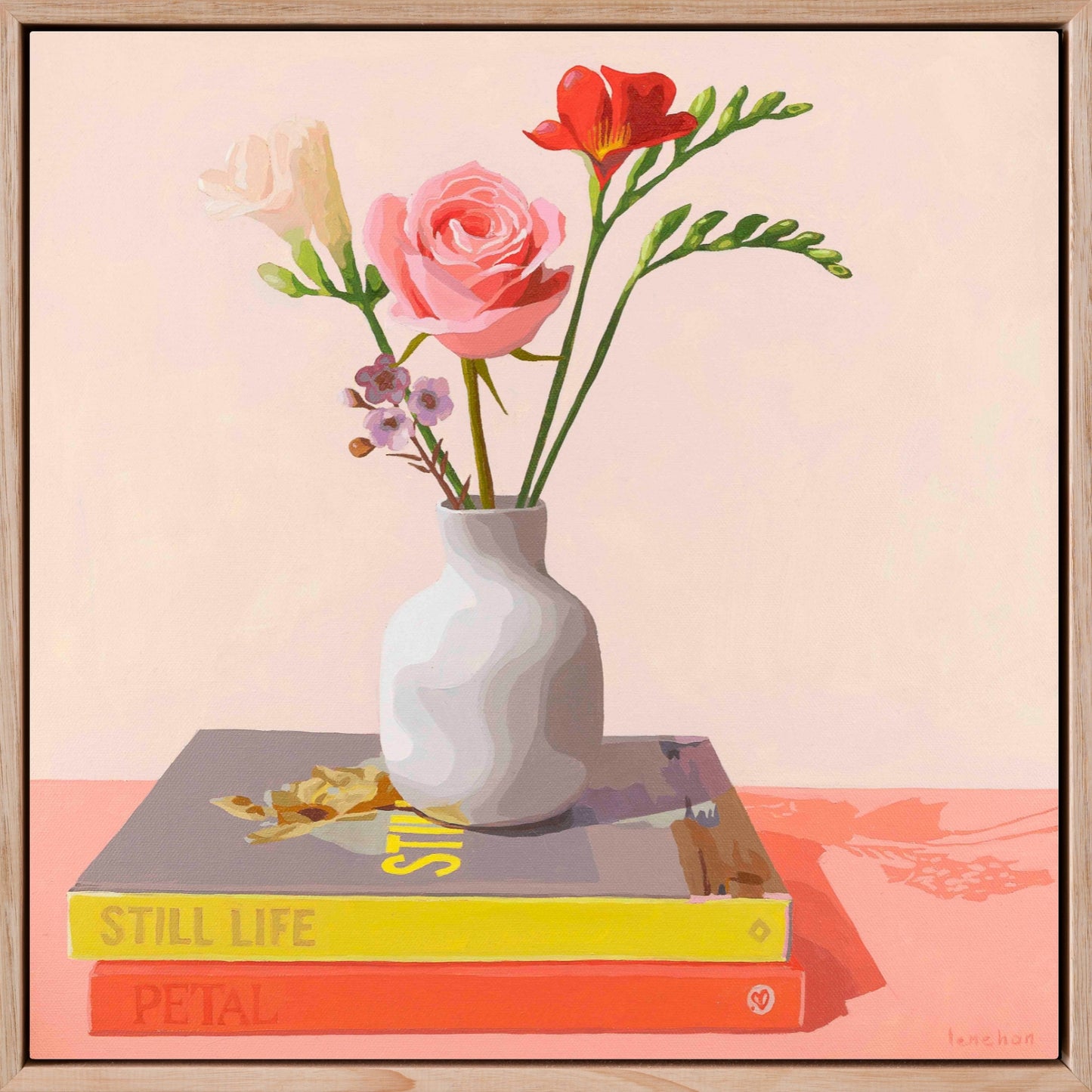 Framed artwork of a vase with flowers on books against a light creamy and peach background