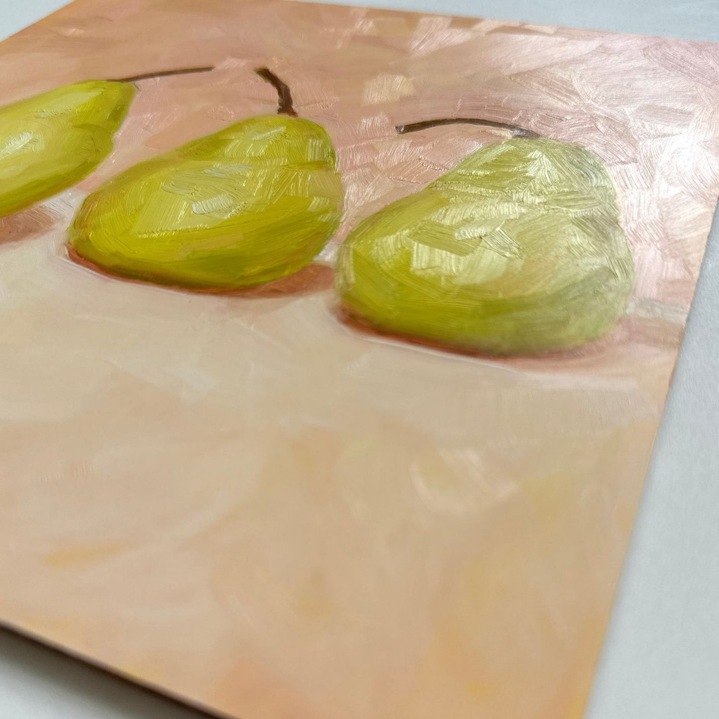 modern and contemporary oil painting of three soft green pears on a soft peach and cream background