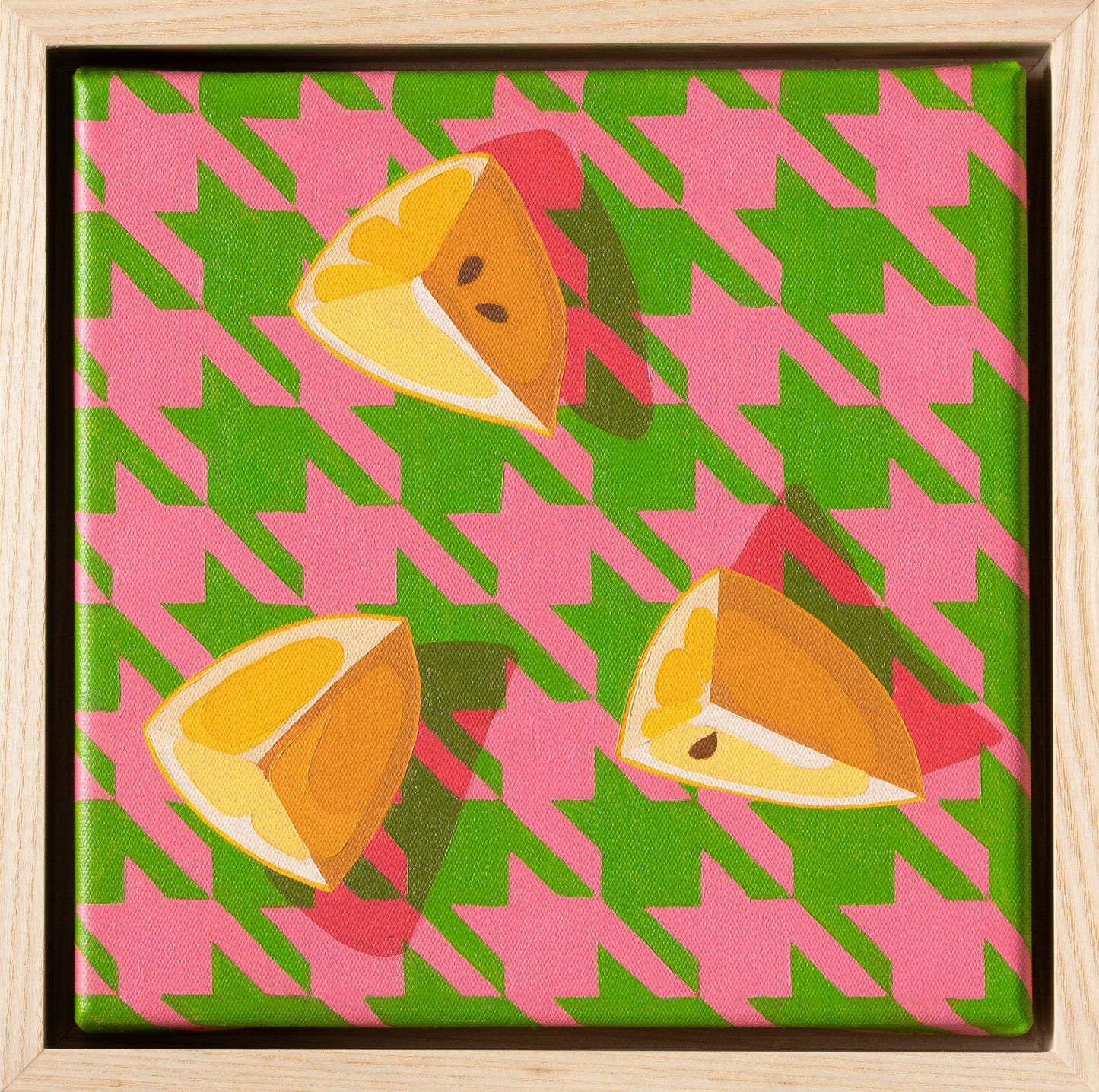 original oil painting of three yellow lemon wedges laying on a bright pink and green background with strong shadows, framed in an American ash shadow box