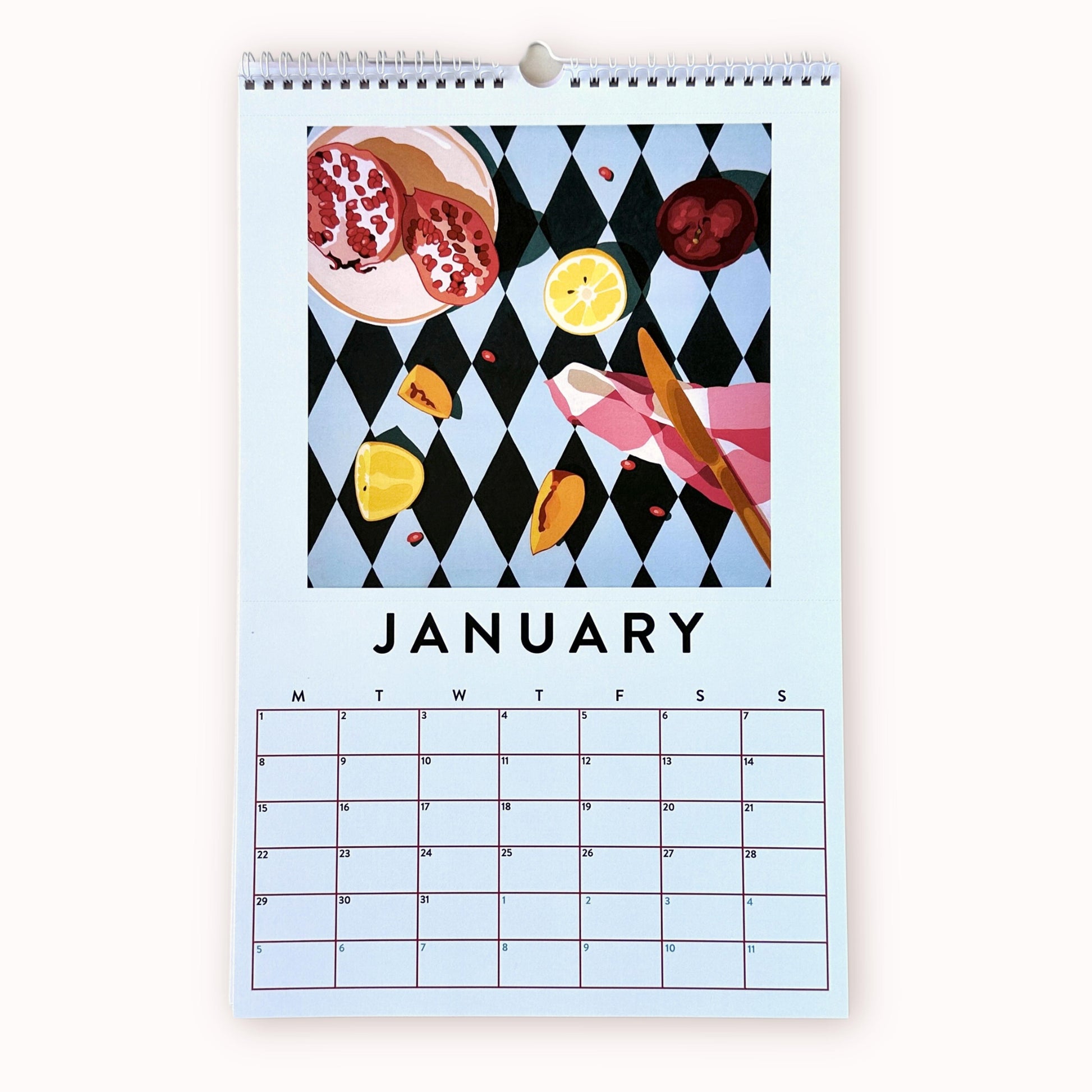 2024 art wall calendar in A3 size for the month of January, featuring a still life oil painting of fruits such as pomegranates with seeds, plum, lemon slices and peach slices, and a chequered tea towel with a knife on a light blue and dark blue harlequin patterned background