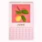 2024 art wall calendar in A3 size for the month of June, featuring a still life oil painting of a lemon with green leaves on a coral pink orange background with strong shadows