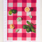art tea towel of gingham checkered background in pink with lemons and limes