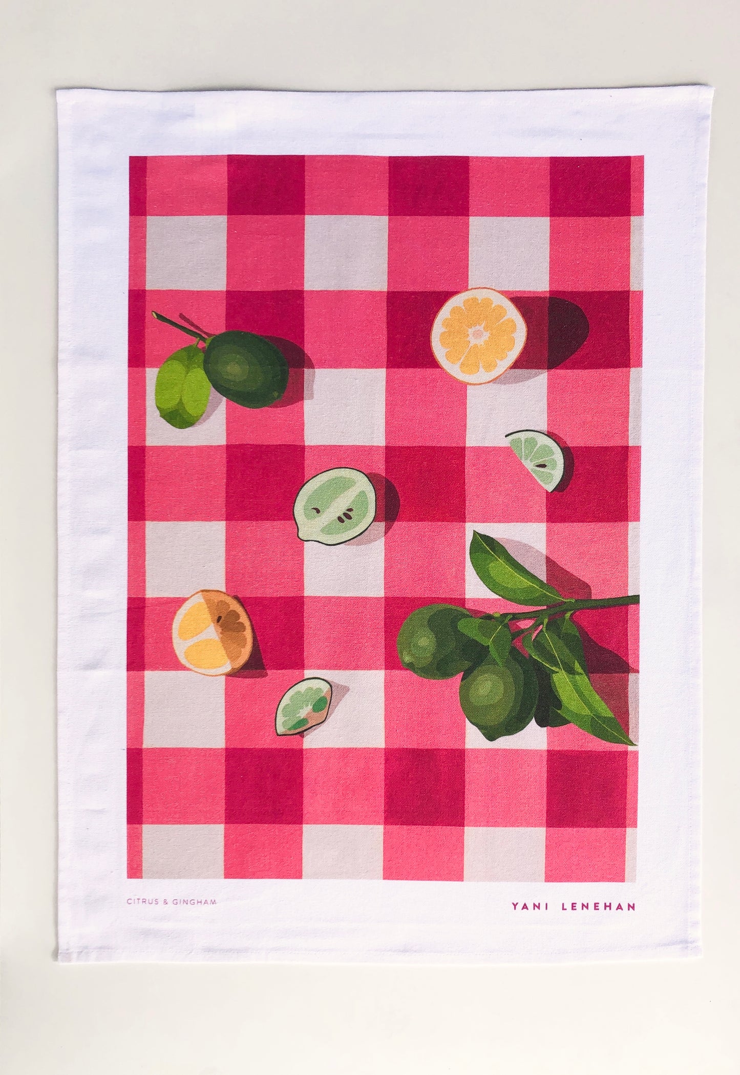 art tea towel of gingham checkered background in pink with lemons and limes