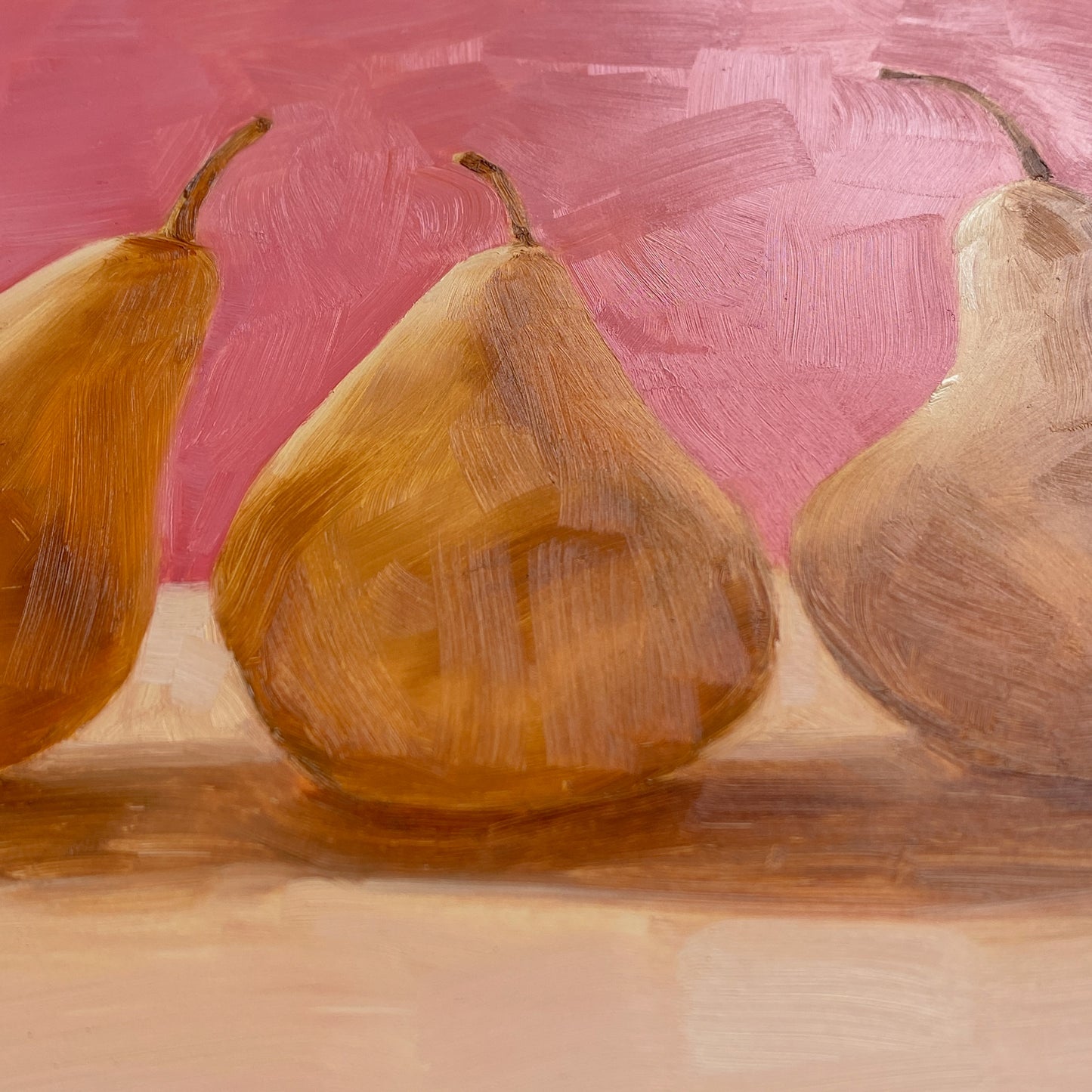 closeup of original oil paintings of three beurre Bosc pears on a warm pink and creamy background where you can see the light reflected on the brushstrokes