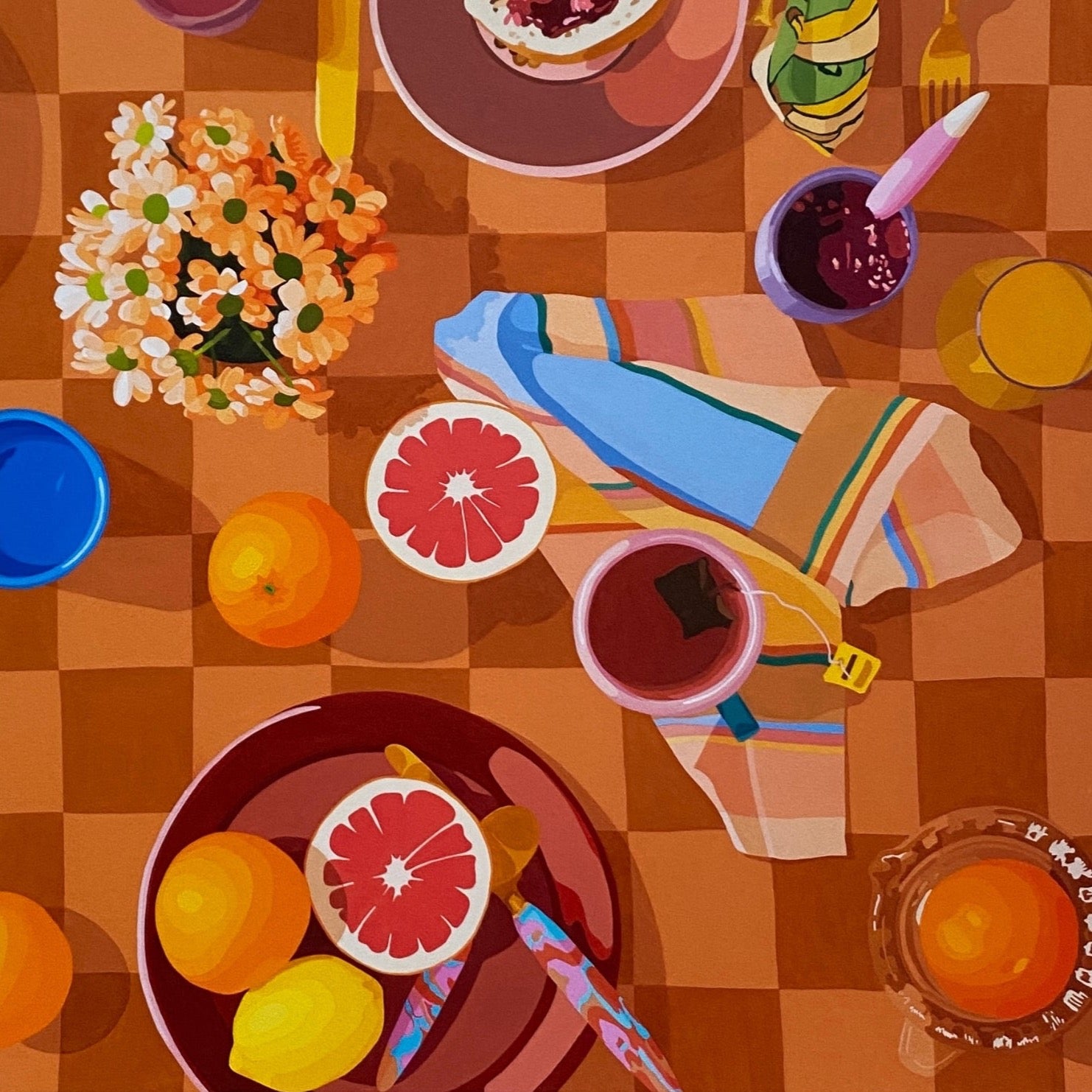 closeup photo of a fine art print of a breakfast setup with oranges, lemons, tea towels, cutlery by kip and co, and flowers and cups on a chequered tablecloth background