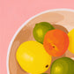 contemporary modern original oil painting of colourful lemons, mandarines and lime fruits in a bowl on a soft pink background