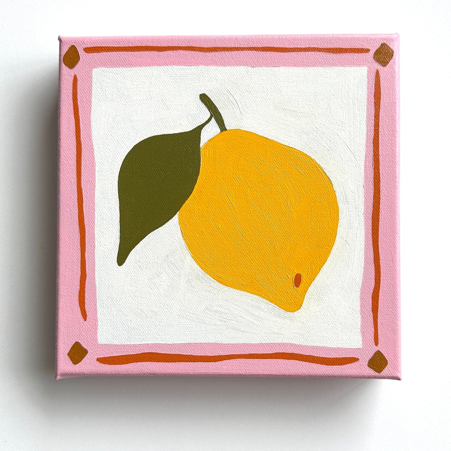 colorful modern and contemporary original oil artwork of a bright yellow lemon with olive green leaves and a pink border by emerging australian artist yani lenehan