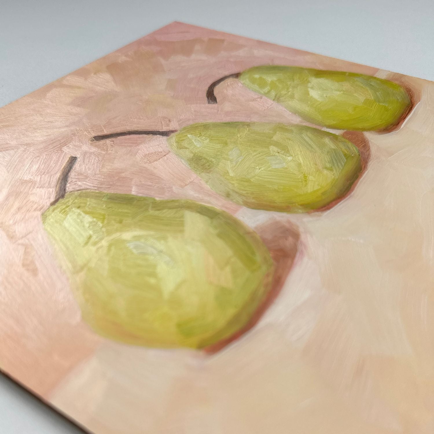 modern and contemporary oil painting of three soft green pears on a soft peach and cream background