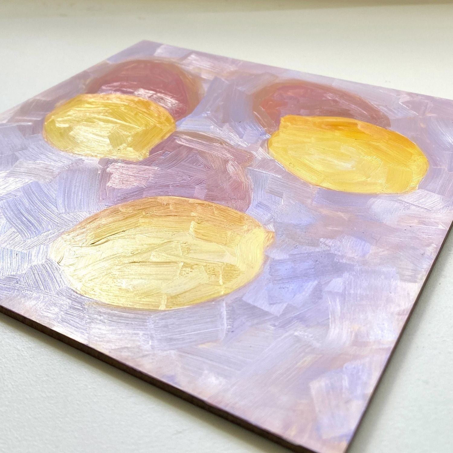 closeup of an original oil painting of three vibrant lemons with strong dark pink shadows on a textured lilac background