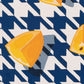 closeup of an original oil painting of three wedges of yellow lemons on a navy blue and white houndstooth background with blue-grey shadows