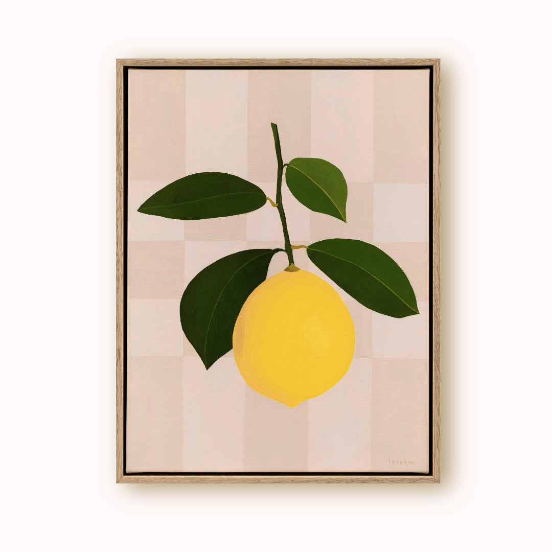 Framed artwork of a yellow lemon with green leaves on a striped background