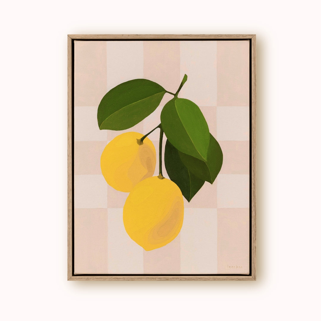 Framed artwork of two yellow lemons with green leaves on a patterned background