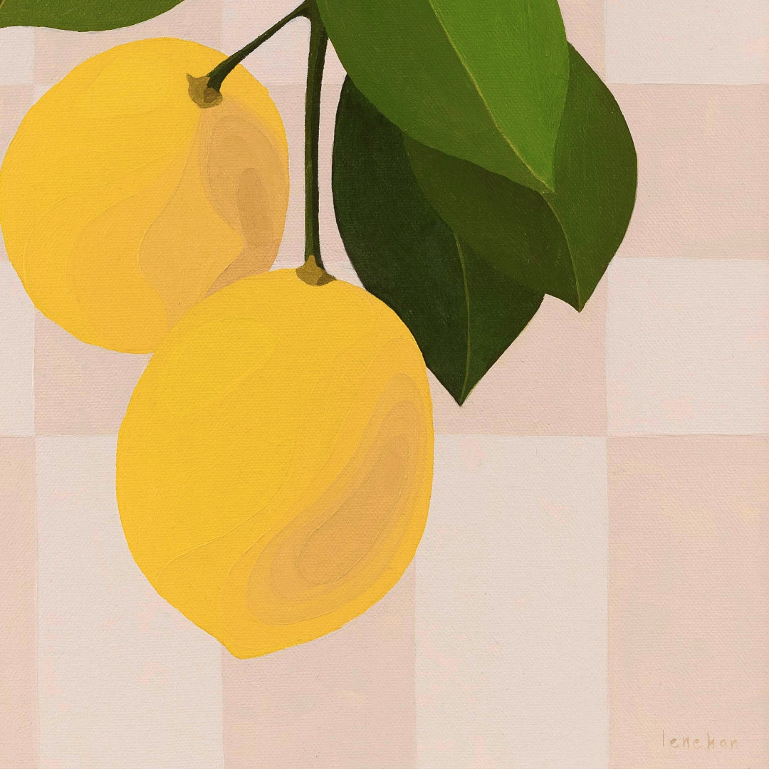Two yellow lemons with green leaves on a checkered background