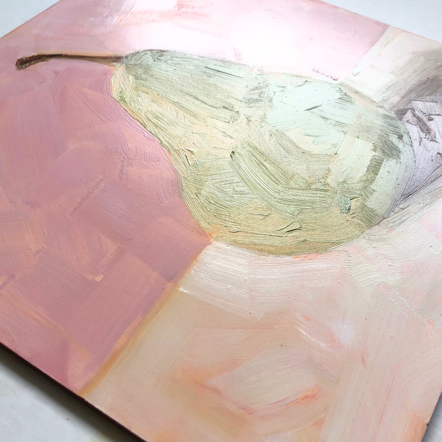 closeup photo of an impressionistic and realistic original oil painting on board of a green pear sitting on a soft pink and cream background