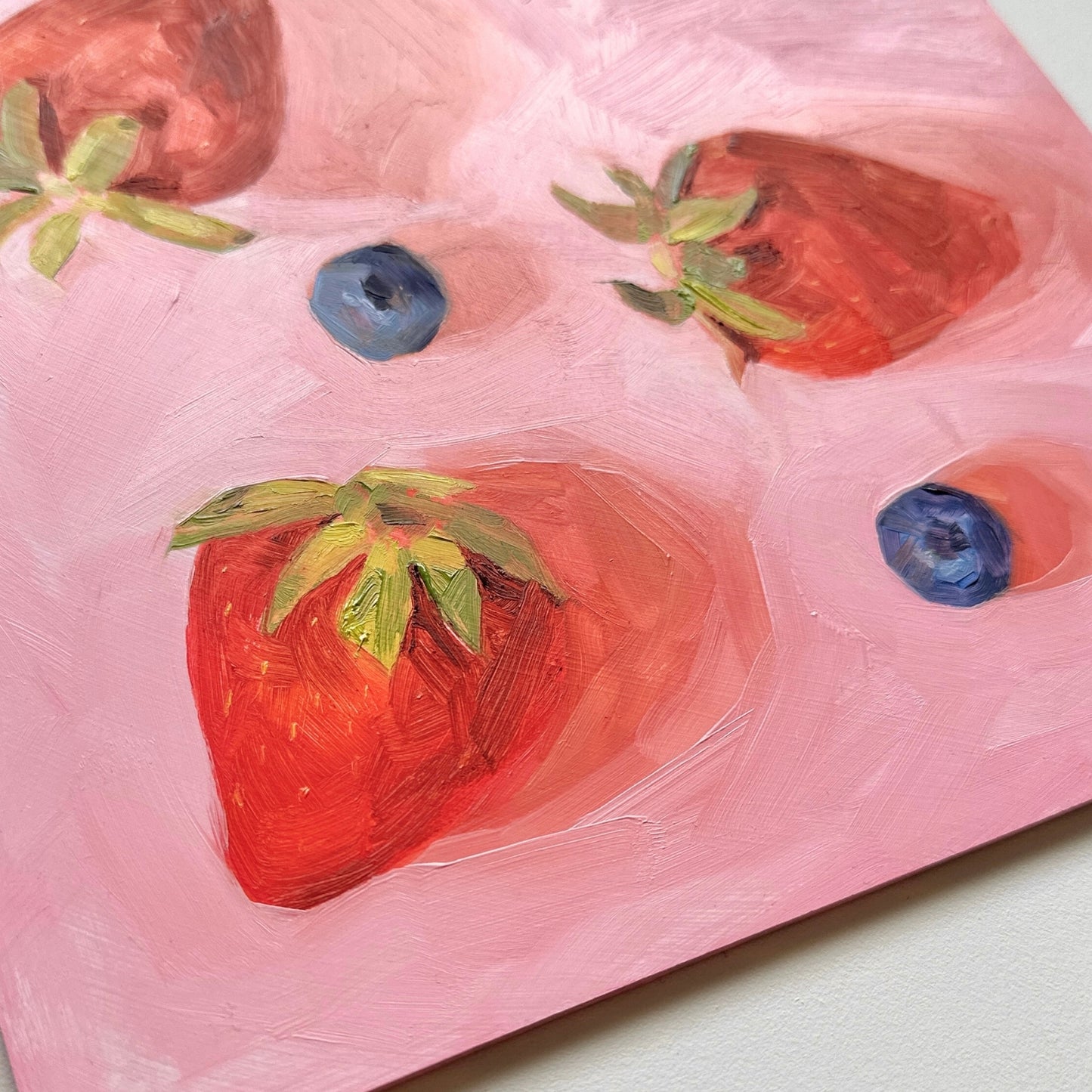 contemporary and modern oil painting of warm red strawberries and blueberries on a textured pink background