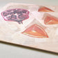 closeup of an impressionistic original oil painting of a still life setting of pomegranate fruit and three orange slices on a textured cream background with soft shadows